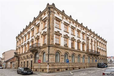 Rohová budova s věží a kamennou fasádou